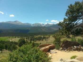 Scenic view of green landscape and mountains against sky