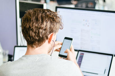 Rear view of man using mobile phone