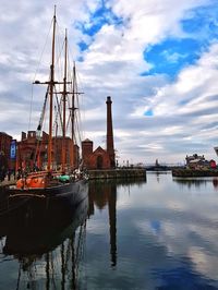 Sailboats moored at harbor