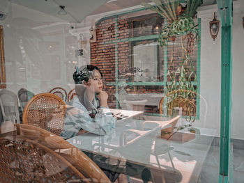 Full length of woman sitting on chair at table