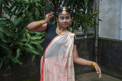 A teenage girl practicing bharatnatyam in nature