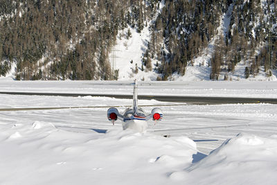 Helicopter on snowy field against trees