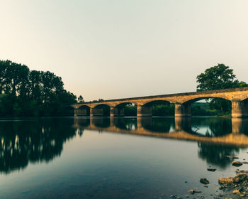 Arch bridge over river against sky