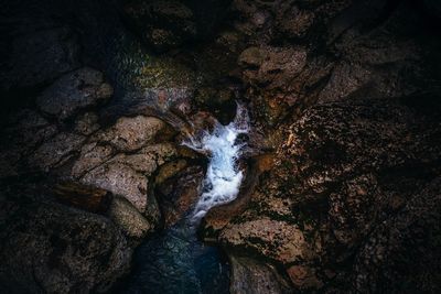 High angle view of stream flowing amidst rock formations