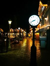 Illuminated clock tower against sky at night