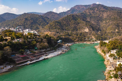 Ganges river flowing through mountains with city nestled at riverbank from top angle