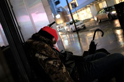 Side view of man holding glass window