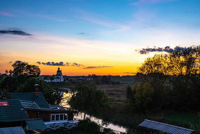 High angle view of trees and buildings against sky during sunset