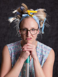 Portrait of woman wearing hair curlers against wall