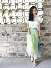 Young woman standing against wall