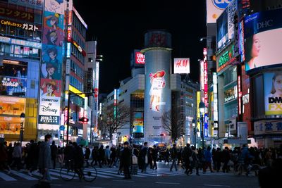 People walking on city street at night