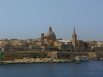 River amidst buildings against clear sky