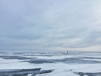 Scenic view of frozen beach against sky during winter