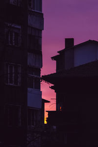 Low angle view of silhouette buildings against sky at dusk