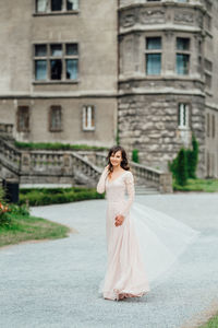 Woman with umbrella standing against building