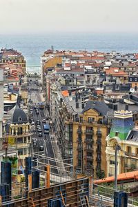 High angle view of townscape by sea against sky