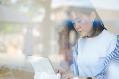 Young woman using mobile phone at home