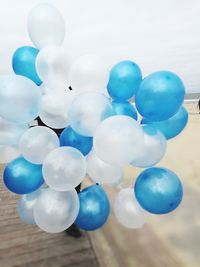 Close-up of multi colored balloons against blue sky