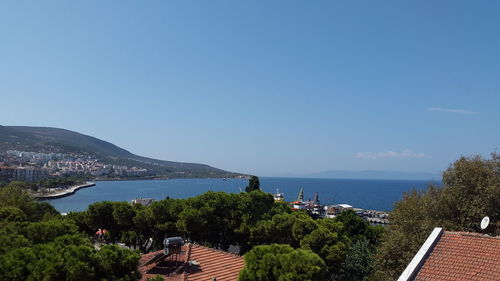 Panoramic view of townscape by sea against clear blue sky