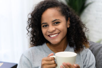 Portrait of a smiling young woman drinking drink