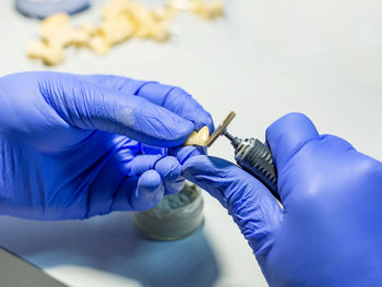 Midsection of person working in blue glass