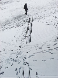 High angle view of person walking by snow covered steps