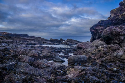 Rock formations by sea against sky