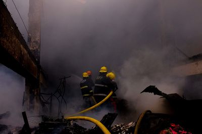 Rear view of firefighters against smoke