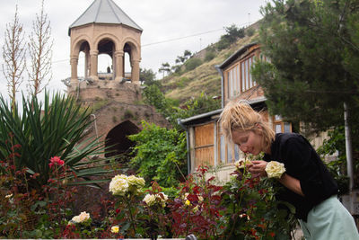 Young woman smelling flowers in city