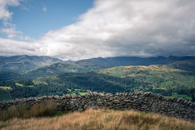 Scenic view of field and mountains against sky