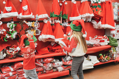 Children choose a santa claus hat in the shop