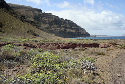 Scenic view of sea and mountains against sky