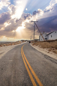 Sunlight through the storm clouds over roadway along chapin beach in cape cod, massachusetts.