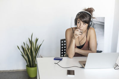 Businesswoman drinking water while sitting at office