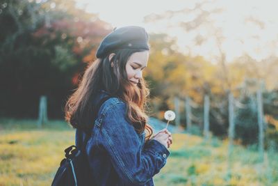 Young woman looking away while standing on plants during winter