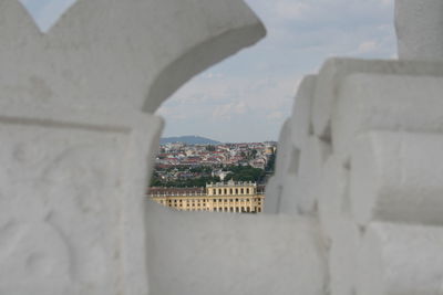 Buildings against sky seen through window