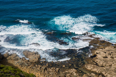 High angle view of waves breaking on rocks