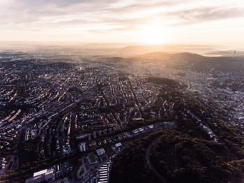 Aerial view of cityscape against cloudy sky during sunset