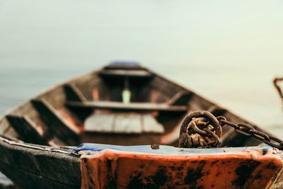 Close-up of rusty tied up on metal against sky