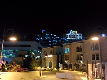 Illuminated city against clear sky at night