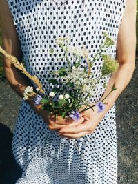 Midsection of woman holding flowers