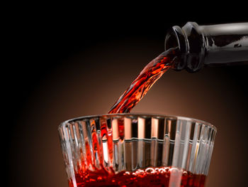 Close-up of red wine in glass against black background