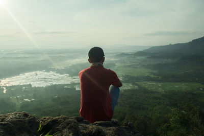 Rear view of a man overlooking landscape