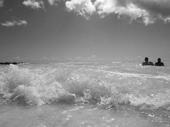 People on sea shore against sky