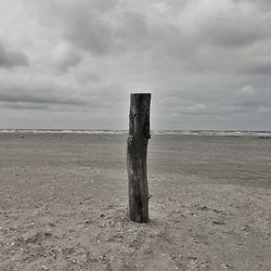 Scenic view of beach against cloudy sky