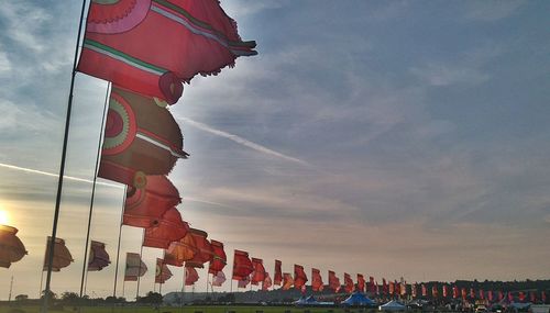 Low angle view of flags against cloudy sky