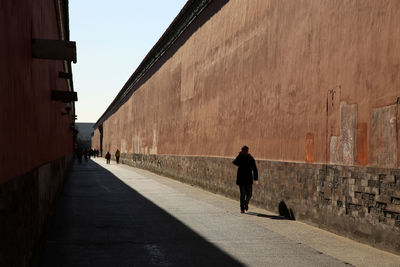 Man walking on street against sky