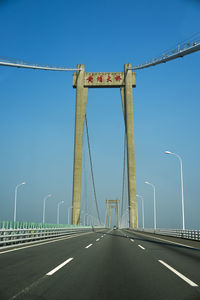 Road against clear blue sky