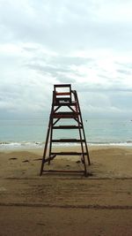 Lifeguard hut on beach against sky