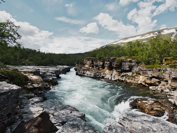 Scenic view of waterfall against sky